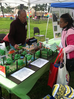 A member of Huerta del Valle showing a model of the future community garden site in Ontario, CA