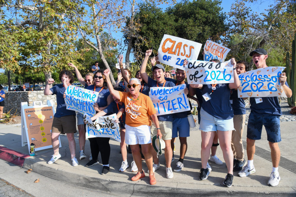Interim President Jill A. Klein greets Pitzer families alongside students holding up welcome to Pitzer signs.