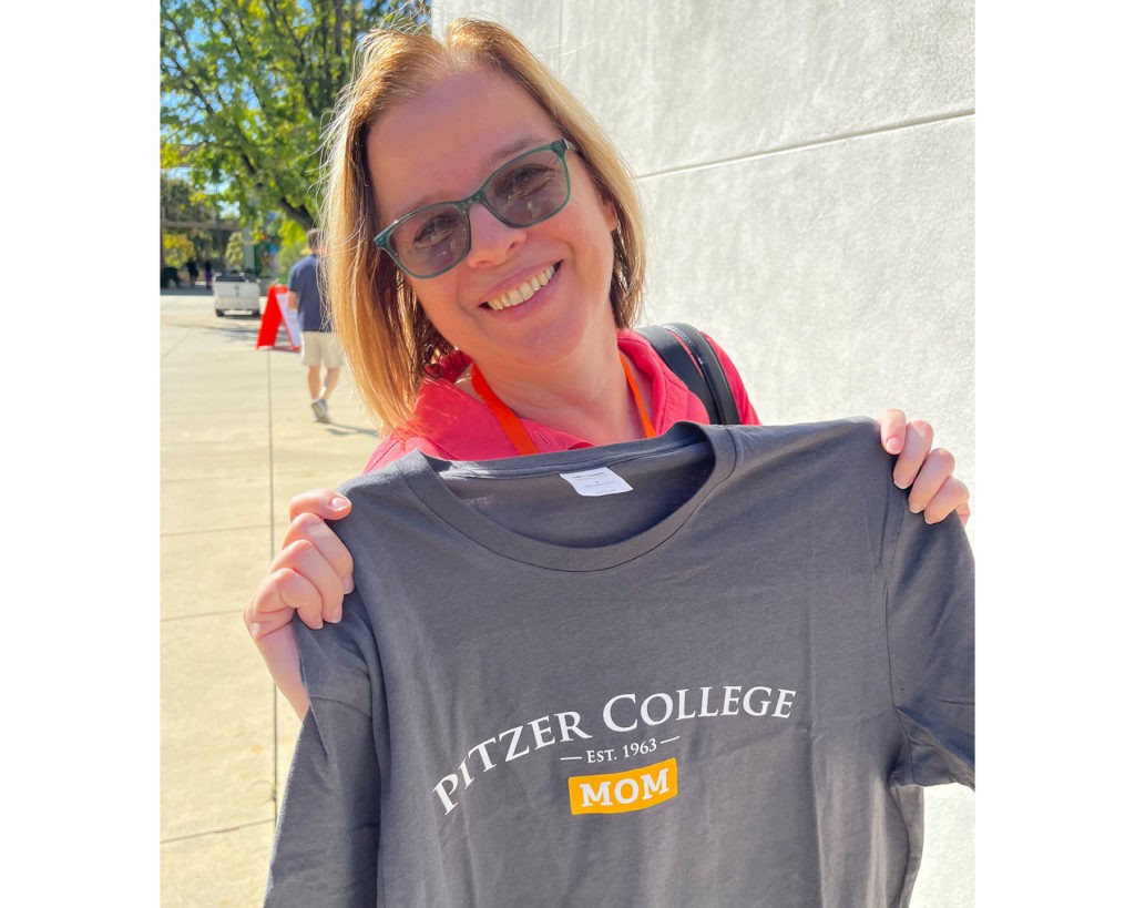 Daniela Frankova holds up a gray Pitzer College Mom T-shirt.