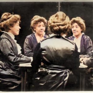 Multigraph photographic portrait of Emma Ransom, Britt Ransom’s great-great grandmother. Four versions of Emma sit around a table, one in profile, one whose back is to the viewer, and two who face the viewer with their gazes focused to the right and left respectively. Emma wears brown hair in an updo and a purplish gray dress with white ruffles on the front.