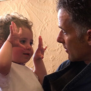 Ella Rosenblatt at two years old holds up both her hands as she looks at her father Jay Rosenblatt.