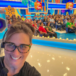 Hayley Blain-Weinstein ’91 wears a headset and takes a selfie in front of the studio audience at The Price is Right.