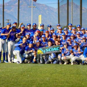 The Pomona-Pitzer men’s baseball team gathers on the field for a group photo while holding up the SCIAC sign.