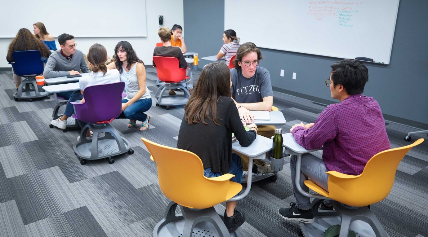 Students discuss in groups of three in a classroom