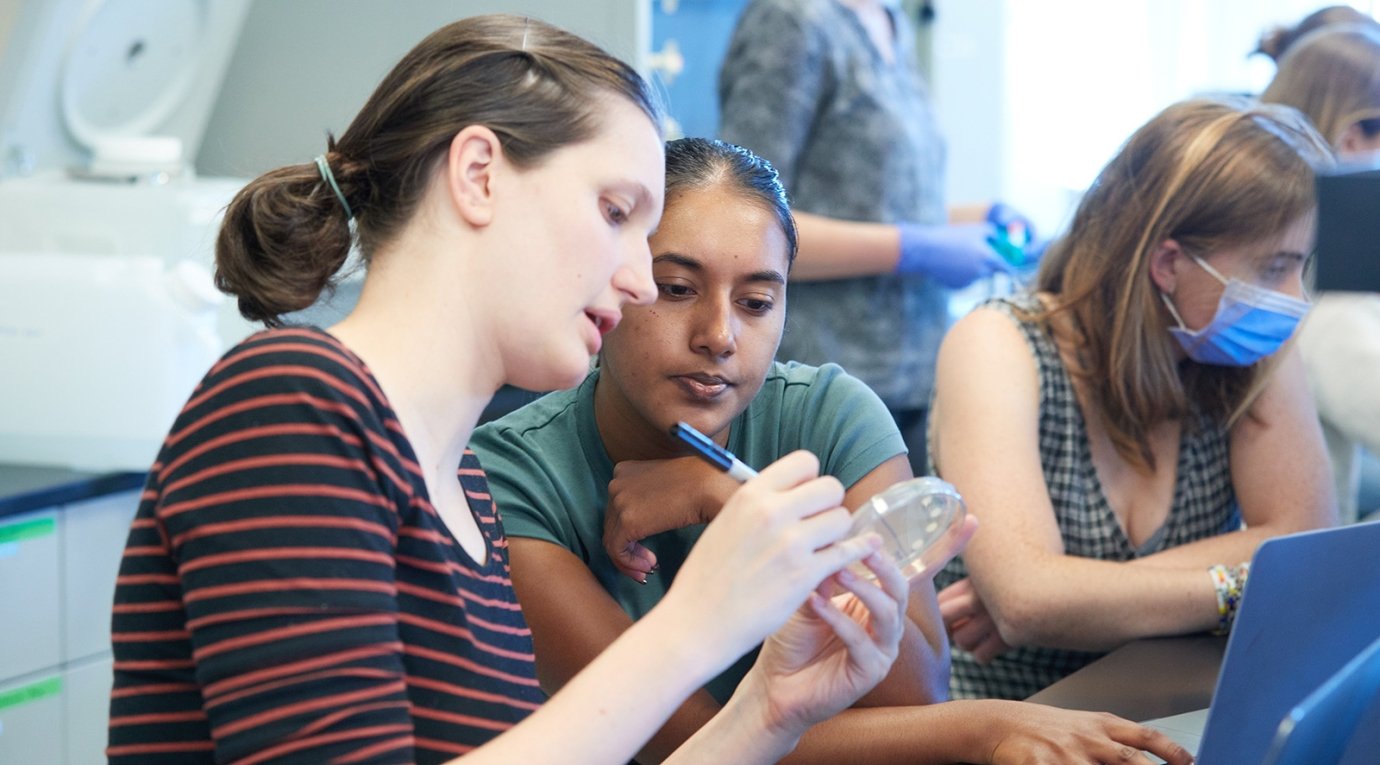 Two students examine a petri dish
