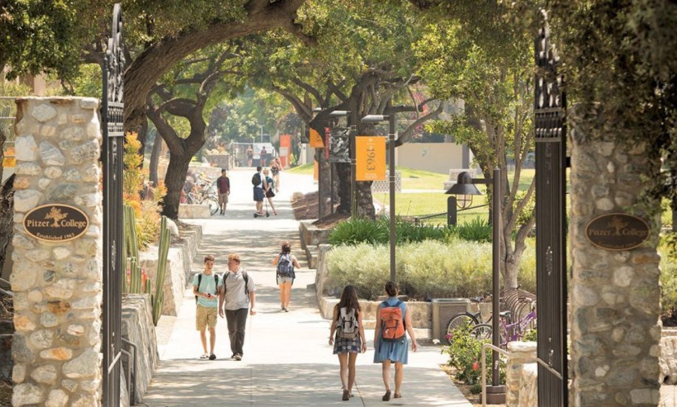Pitzer College gates with students walking