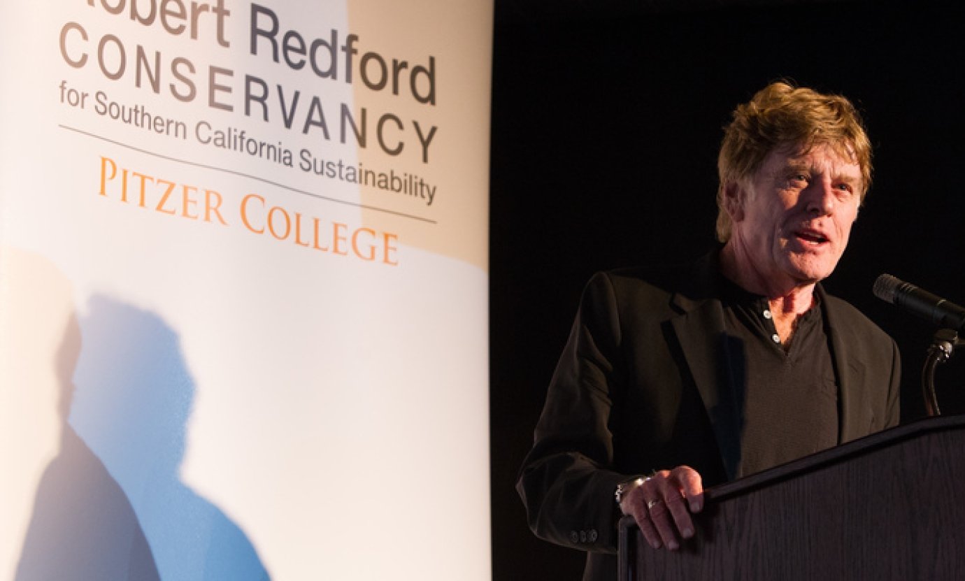robert redford talks at a podium