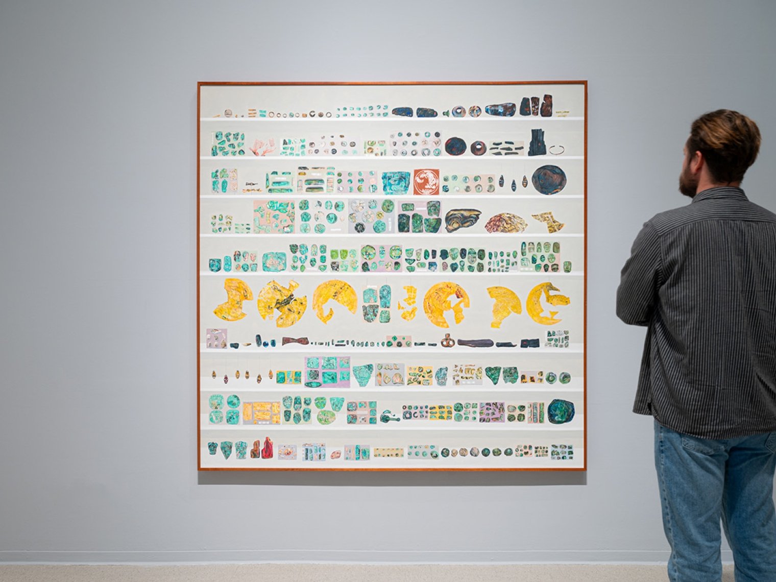 A person looks at a collection of artifacts from Gala Porras Kim's exhibition “Between Lapses of Histories”