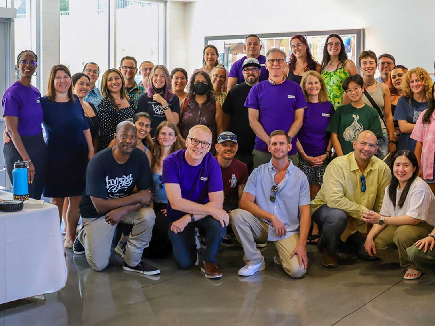 a large group poses for a photo in the Scott Hall lobby at the Justice Education Center kickoff part