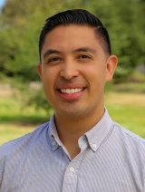 Man with short black hair wearing white button up shirt.