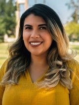 headshot of Elisa Albán-Ashley with the Pitzer clock tower in the background