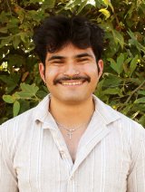 portrait of marcus gomez standing in front of a shrub