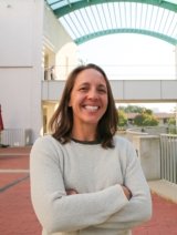 Woman in short brown hair wearing white sweater.