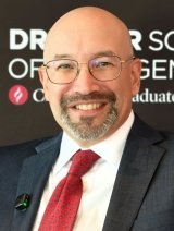 headshot of Adrian Pantoja wearing a white collared shirt, red tied, and black blazer