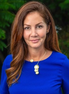 portrait of Laura Schaefer wearing an electric blue blouse and silver necklace