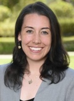Violet Luxton Pitzer staff member portrait with greenery in the background.