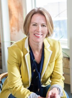 Woman in yellow blazer and navy shirt.