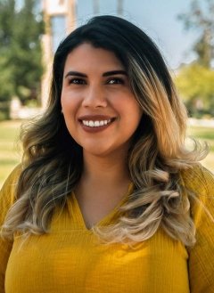 headshot of Elisa Albán-Ashley with the Pitzer clock tower in the background