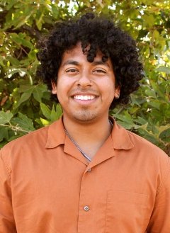 portrait of John Villalta in front of a shrub