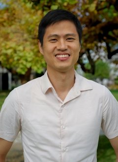 Man wearing white button up with short black hair.