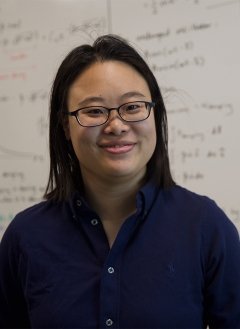 Woman in black top wearing glasses with black short hair.