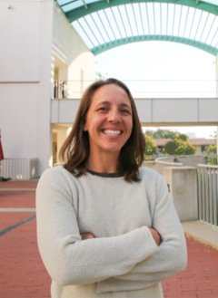 Woman in short brown hair wearing white sweater.