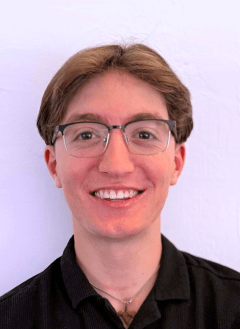 Student in black shirt wearing glasses with blonde hair. 