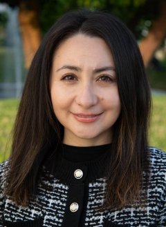 Woman with dark brown hair wearing black and white coat. 