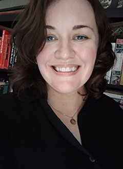 a woman smiling in front of a bookcase