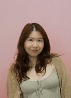 Iris Huang standing in front of a pink wall