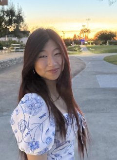 a girl in a white dress standing in front of a sunset