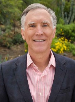 a portrait of strom thacker with the pitzer landscape behind him