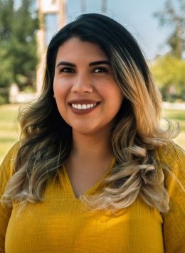 headshot of Elisa Albán-Ashley with the Pitzer clock tower in the background