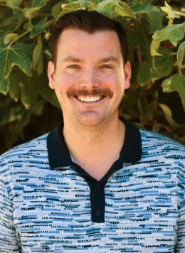 Man with blue collar shirt and brown short hair.