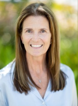Woman in light blue blouse with short brown hair.