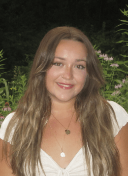 Woman in white blouse with long blonde hair.