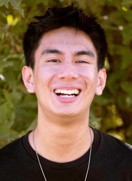 head shot of Kian Ayno standing in front of outdoor greenery