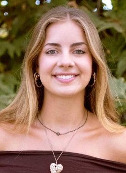 head shot of Sadie Blain standing in front of outdoor greenery