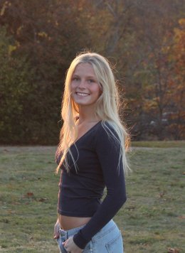 Birdie Hawkins stands in front of a field during sunset