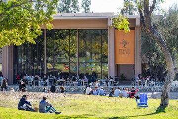 students sit on the mounds in front of McConnell Center