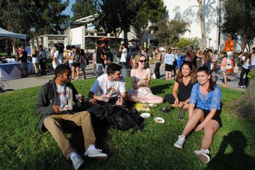 Students sitting in grass eating in 2014.