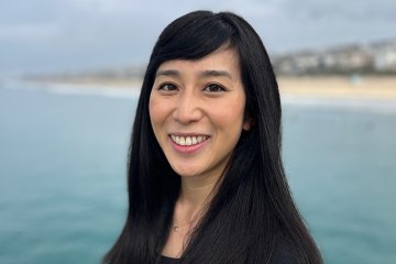 headshot of Rosanna Xia with the sea and a shoreline behind her
