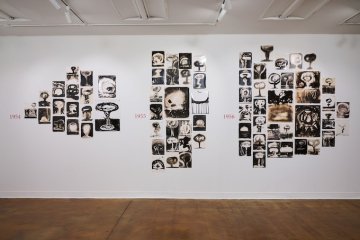 photographic drawings of mushroom clouds arranged on a wall