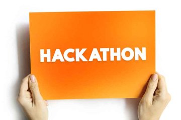 two hands hold up an orange sign with the words "hackathon" printed on it in white