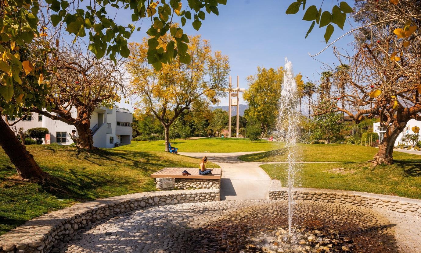 a student sits near the pitzer fountain