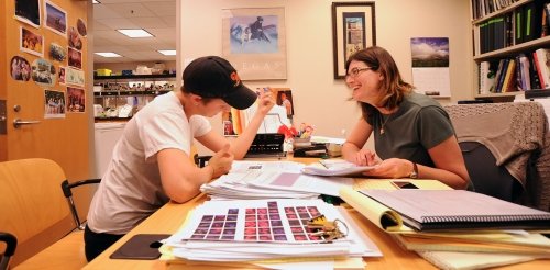 A biology professor advises a student in their office