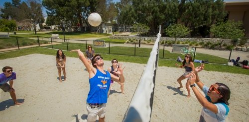 Student play beach volleyball on campus