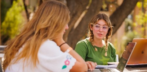 two students study at an outside table in scott hall courtyard