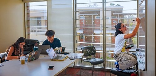 three students use a study room in a residence hall