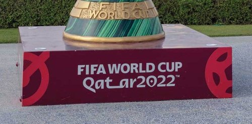 The base of a statue of the world cup trophy with text that reads "FIFA World Cup, Qatar 2022."